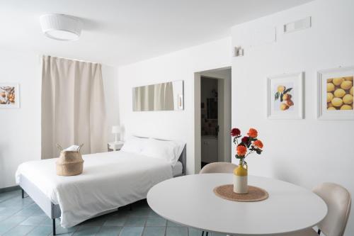 een witte kamer met 2 bedden en een tafel bij Dimora Santa Caterina in Polignano a Mare