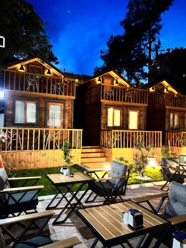 a log cabin with a table and chairs in front of it at My Home Hotel Gulluk in Antalya