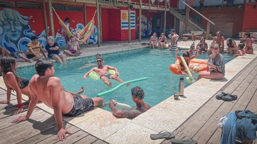 grupa ludzi bawiących się w basenie w obiekcie Compay Hostel La Pedrera w mieście La Pedrera