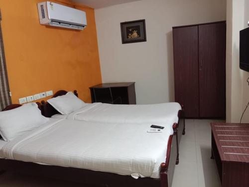 a bedroom with a bed and a television in it at GUINDY CHENNAI STAYS in Chennai