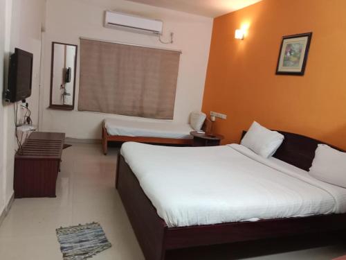 Cette chambre comprend un grand lit et une fenêtre. dans l'établissement GUINDY CHENNAI STAYS, à Chennai