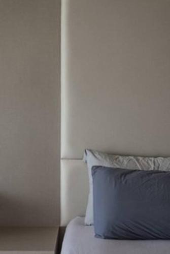 a bed with a blue pillow in a bedroom at Deluxe Seaview Suite King Bed by The Only Bnb in Tanjong Tokong
