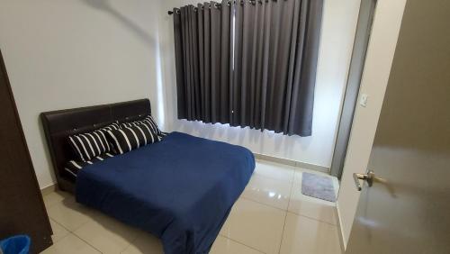 1 dormitorio con 1 cama con manta azul y ventana en TL145 The Strata, en Kajang