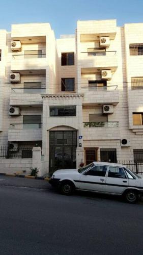 a white car parked in front of a building at شقه مفروشه سوبر ديلوكس in Amman