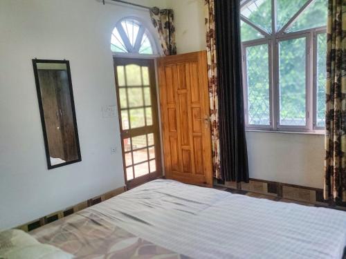 an empty bedroom with a bed and two windows at Gaharwar Home Stay in Dehradun