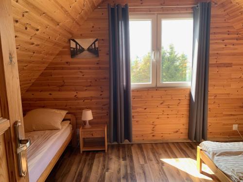 ein Schlafzimmer mit einem Bett in einem Holzhaus in der Unterkunft Domki u Karola in Rewal