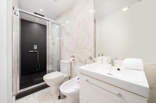 a white bathroom with a toilet sink and a shower at Downtown Lux Apartment in Faro