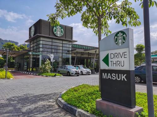 a sign in front of a car dealership with cars parked at 2-8pax Ipoh Nomado Onsen suites by Sunway Onsen Lost world of Tambun in Ipoh