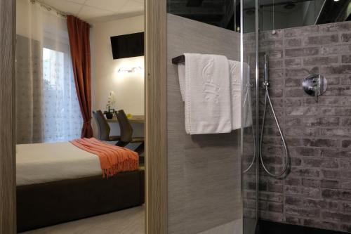 uma casa de banho com uma cama e uma cabina de duche em vidro em LeNotti Verona em Verona