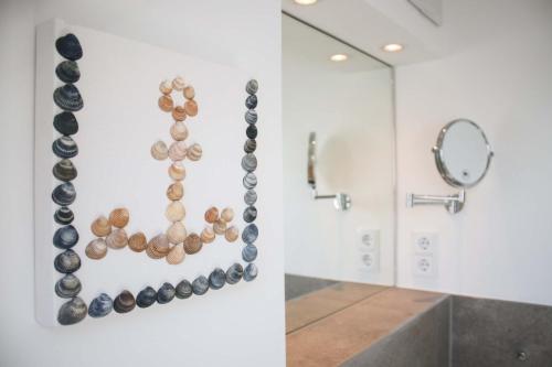a bathroom with shells on the wall and a mirror at Lüttjeod - Apartment 17 in Langeoog