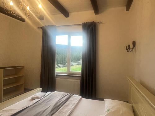 a bedroom with a bed and a window at Мелодія Гір .Апартаменти з видом на гори . in Vorokhta