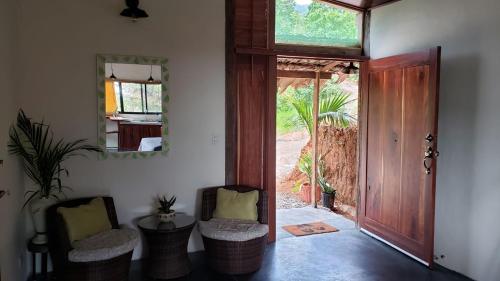 Zimmer mit einer Tür, 2 Stühlen und einem Spiegel in der Unterkunft Cabina Brisa Escondida - Walking distance from river in Savegre