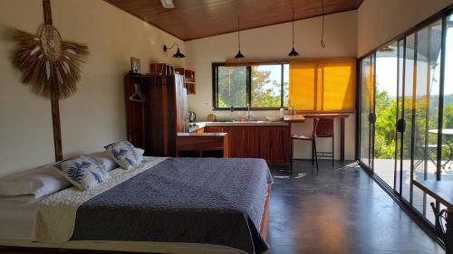 1 dormitorio con 1 cama y cocina con fregadero en Cabina Brisa Escondida - Walking distance from river, en Savegre