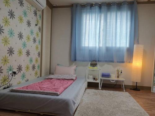 a small bedroom with a bed and a window at Cozy accomodation near chilgok gyeongdae hospital in Daegu