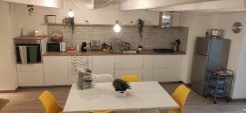 eine Küche mit einem weißen Tisch und gelben Stühlen in der Unterkunft CasaMas in Brindisi