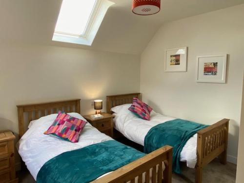 a bedroom with two beds and a window at Oakwood in Lymington