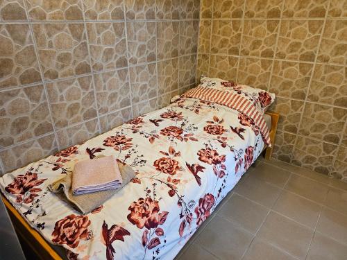 a bedroom with a bed with a floral bedspread at Szilvás 10 in Szigliget