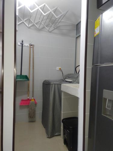 cocina con mesa y nevera en una habitación en Apartamento amoblado NUEVO frente sede selección Colombia, en Barranquilla