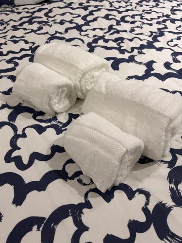 2 rotoli di asciugamani bianchi su un letto di Mar&Sal Vila do Conde a Vila do Conde