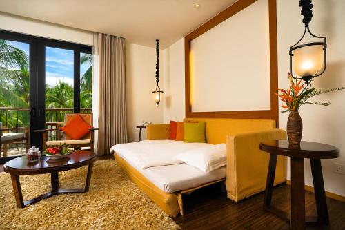 a hotel room with a bed and a table and a window at Tanjung Rhu Resort in Tanjung Rhu 