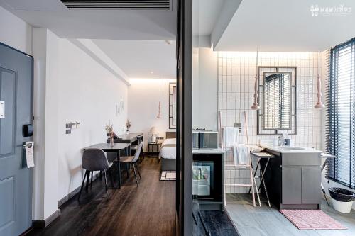 a kitchen and dining room with white walls and wood floors at SOOKNIRUND HOTEL in Chiang Rai