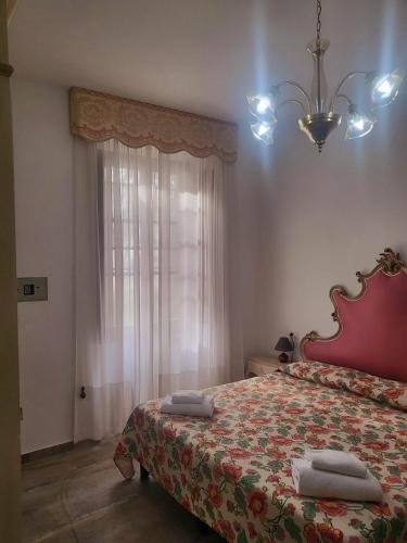 a bedroom with a bed with a red bedspread and a window at Villa Torricelli Scarperia - Il Giardinetto Residence in Scarperia