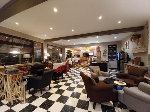 a lobby with couches and chairs and tables at Logis Hotel Eden Lac in Savines