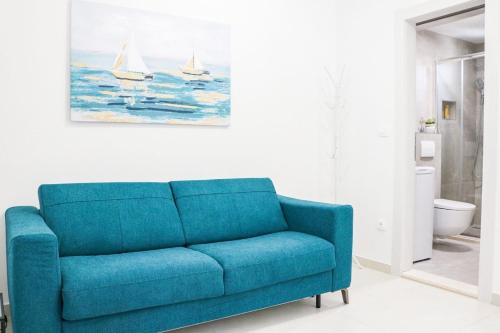 Cosmo apartment في دوبروفنيك: أريكة زرقاء في غرفة المعيشة مع لوحة