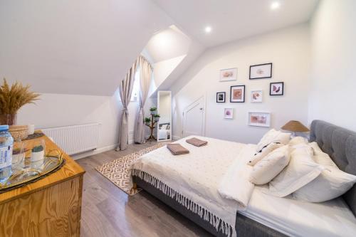 um quarto com uma cama com lençóis brancos e almofadas em Dom nad Rzeką em Raciechowice