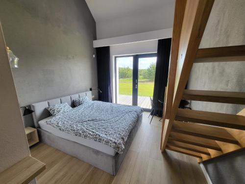 - une chambre avec un lit et une grande fenêtre dans l'établissement Orli Zakątek, à Gorczyca
