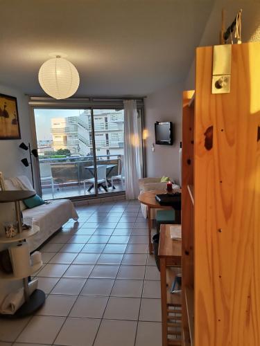 a living room with a couch and a large window at Port LEUCATE T2 vue mer 100m de la plage in Port Leucate