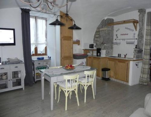 een keuken met een tafel en stoelen in een kamer bij Charmant gîte 2 étoiles, parking privé à Ruoms in Ruoms