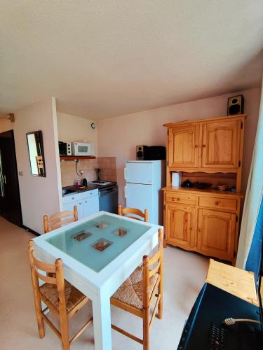 a kitchen with a white table and chairs in a room at Appartement T2 CABINE Résidence Eugénie in Luz-Saint-Sauveur