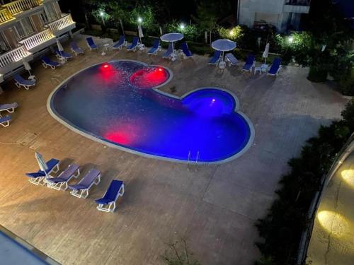 an empty swimming pool with chairs and tables at Студио Симона 3 - първа линия море in Lozenets