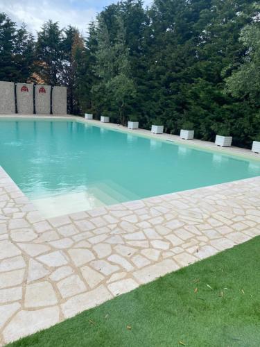 a large swimming pool with blue water at Appia Antica Hotel in Corato