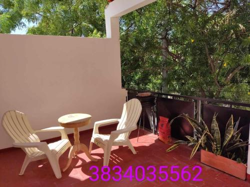 two chairs and a table on a patio with a fireplace at Hermoso departamento, excelente ubicación in San Fernando del Valle de Catamarca