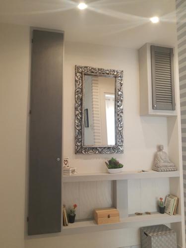a bathroom with a mirror and a shelf with a sink at Zahira2 in Rapallo