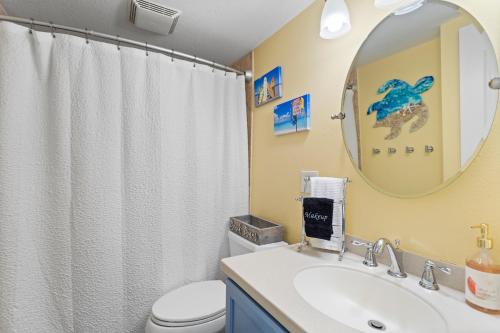 La salle de bains est pourvue d'un lavabo, de toilettes et d'un miroir. dans l'établissement Funshine Sunset Beach, à St. Pete Beach
