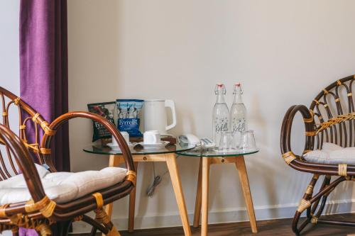 a glass table with two chairs and bottles on it at JM Boutique Hotel in Phu Quoc