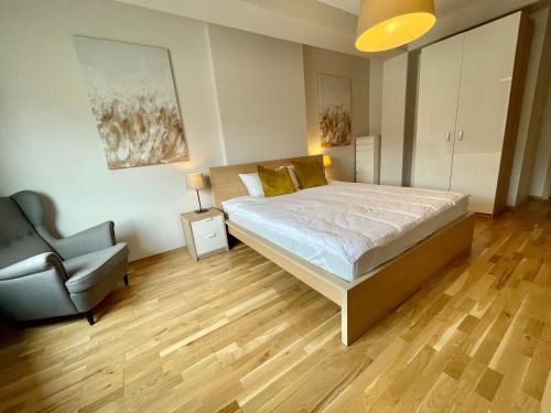 1 dormitorio con 1 cama y 1 silla en Boutique Apartments - Old Town 120m2 - Private Underground Parking -, en Wroclaw