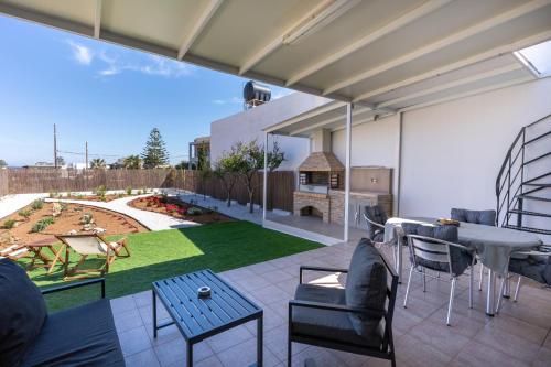 a patio with a table and chairs and a garden at Delis Villa in Kato Gouves