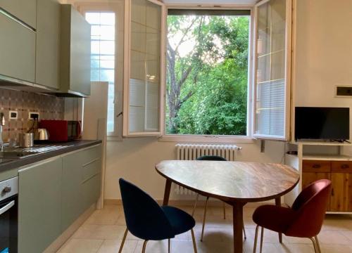 een keuken met een tafel en stoelen en een raam bij Golden Age in Ferrara