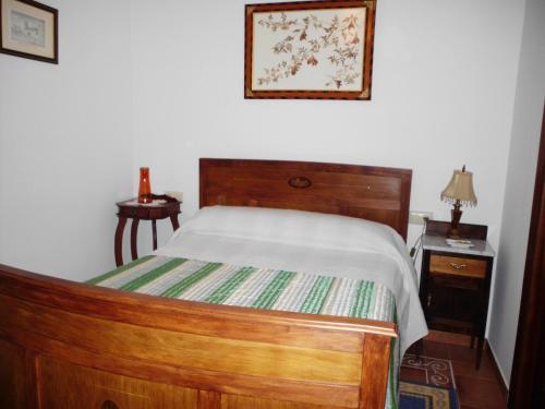 a bedroom with a wooden bed and two night stands at Casa Rural Morada Maragata in Cózar