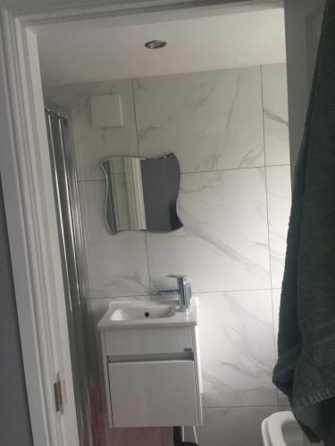 a white bathroom with a sink and a mirror at home away from home in Croydon