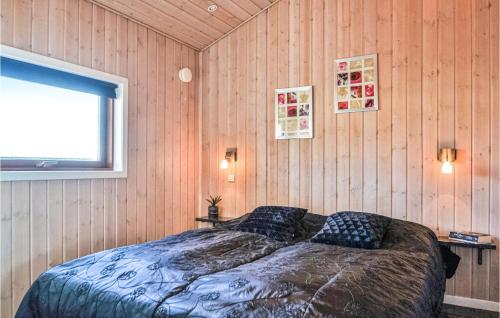BjerregårdにあるBeautiful Home In Hvide Sande With Saunaの木製の壁のベッドルーム1室