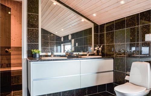 BjerregårdにあるBeautiful Home In Hvide Sande With Saunaのバスルーム(洗面台2台、トイレ付)