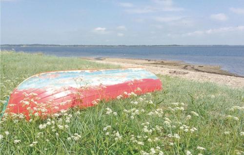 a boat sitting in the grass next to a beach at 5 Bedroom Stunning Home In Øster Assels in Øster Assels
