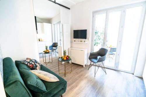 ein Wohnzimmer mit einem grünen Sofa und Stühlen in der Unterkunft Appartement Bocuse -terrasse -Oullins-Lyon in Oullins