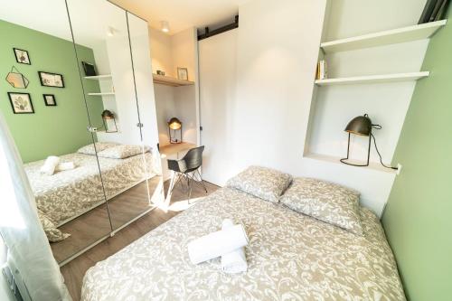 Schlafzimmer mit einem Bett und einem Spiegel in der Unterkunft Appartement Bocuse -terrasse -Oullins-Lyon in Oullins