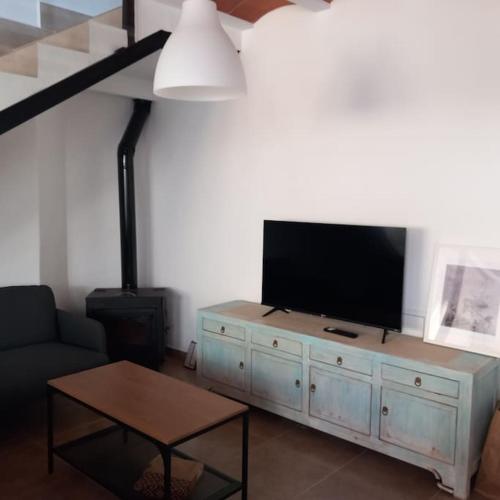 a living room with a flat screen tv on a cabinet at Casa rural La Azuleja de Alatoz in Alatoz